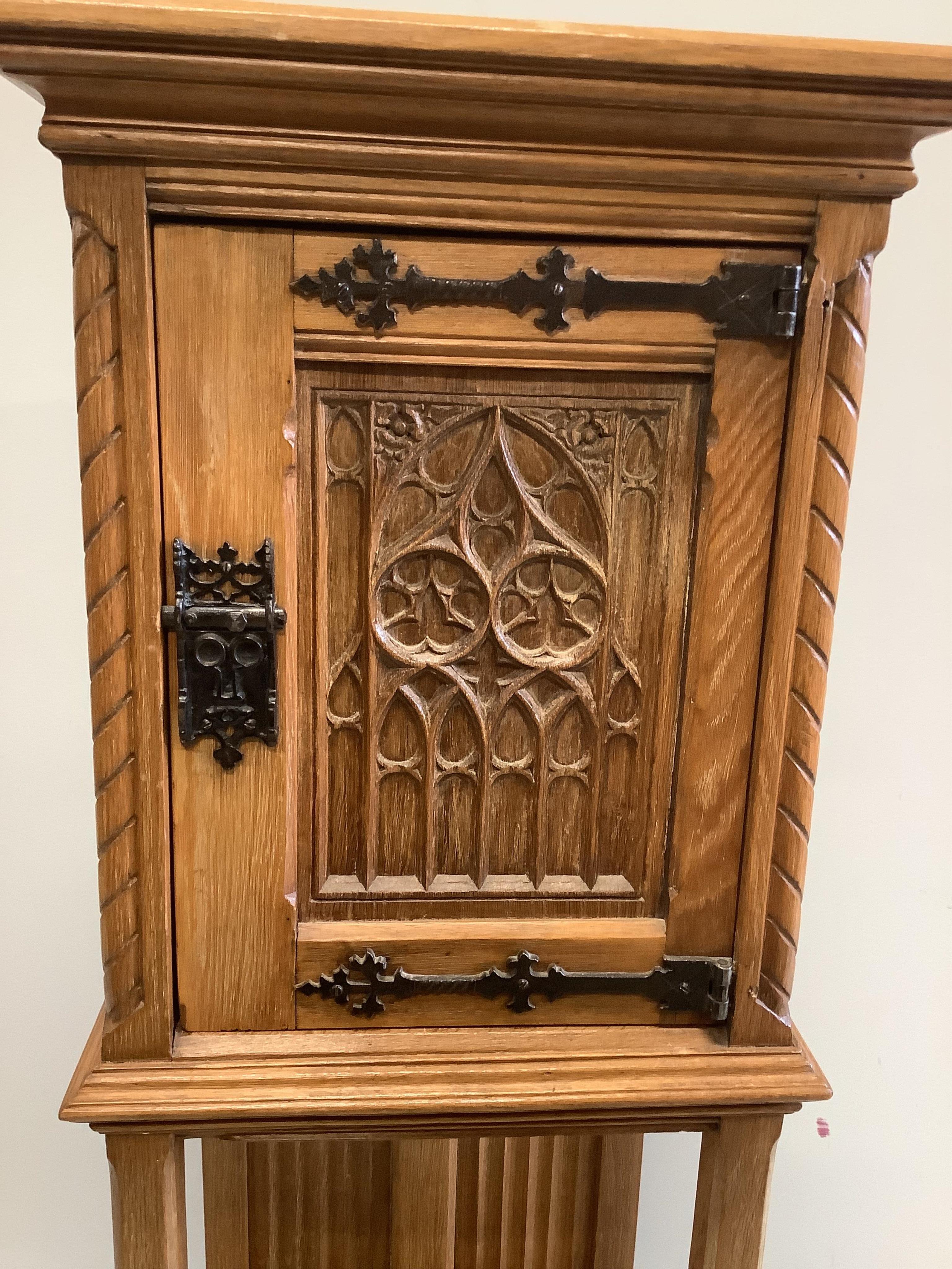 A Gothic Revival oak cabinet on stand, width 46cm, depth 38cm, height 127cm. Condition - fair